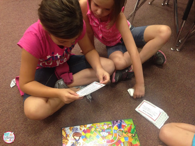 two girls in pink shirts playing candy land with task cards 