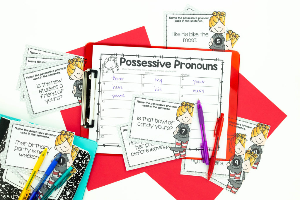 Possessive Pronoun task cards and recording sheet on red clipboard with colored pens